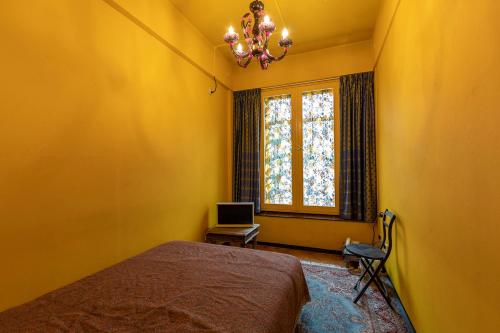 a yellow bedroom with a bed and a window at Hotel Bazar in Rotterdam