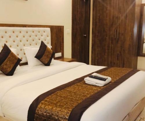 a bedroom with a bed with two remote controls on it at Mayda Inn- A Boutique Hotel in New Delhi