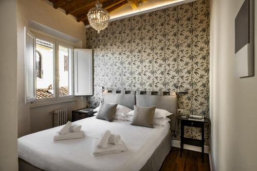 a bedroom with a large white bed with two towels on it at Parione Uno in Florence