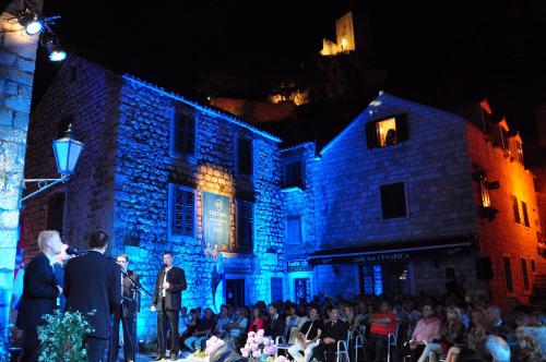 a group of people standing in front of a building with blue lights at Hotel Villa Dvor in Omiš