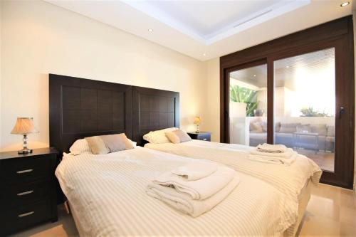 two beds in a bedroom with towels on them at Estepona East Apartment MIA in Estepona