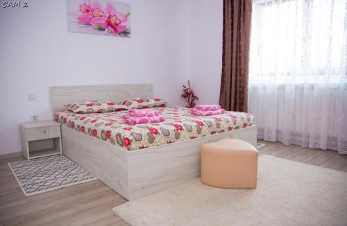 Un dormitorio con una cama con almohadas rosas. en Casa Stefania 1, en Călimăneşti