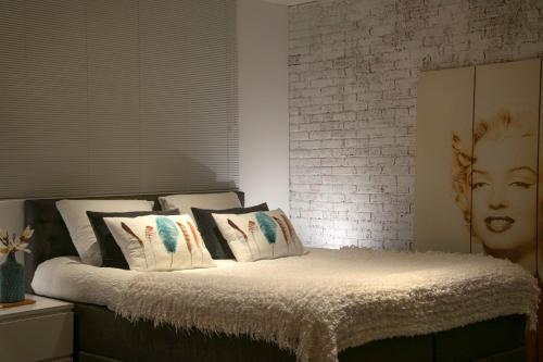 a bedroom with a bed with pillows and a brick wall at B&B Sloterpark in Amsterdam