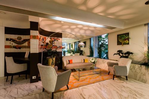 a living room with a couch and chairs at Hôtel Hélios in Juan-les-Pins
