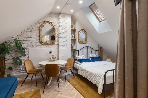 a bedroom with a bed and a table and chairs at Apartments Satva in Vilnius