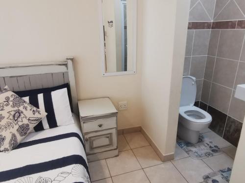 a small bathroom with a bed and a toilet at Seahorse unit 4 in Scottburgh