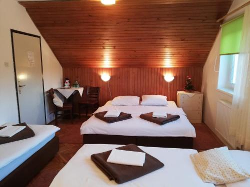 um pequeno quarto com duas camas e uma mesa em Guesthouse Arnika em Fuzine