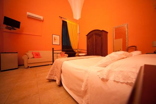 two beds in a room with orange walls at B&B Dimora San Vincenzo in Gallipoli