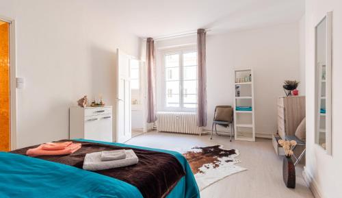 une chambre avec un lit avec une couverture bleue dans l'établissement Ô Palais de justice - 4 personnes, au Havre