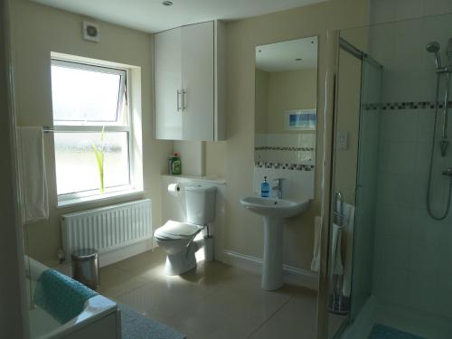 a bathroom with a toilet and a sink and a shower at Chesil View House in Portland