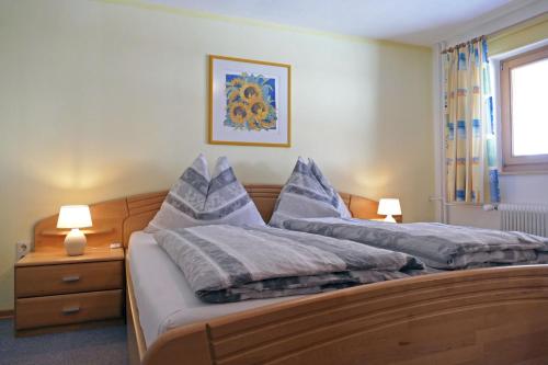 a bedroom with a large bed with blue pillows at Haus Maringele in Nesselwängle