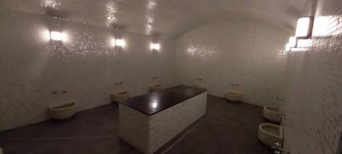 a bathroom with three urinals and three toilets in a room at Golden Tulip Royaume in Alger