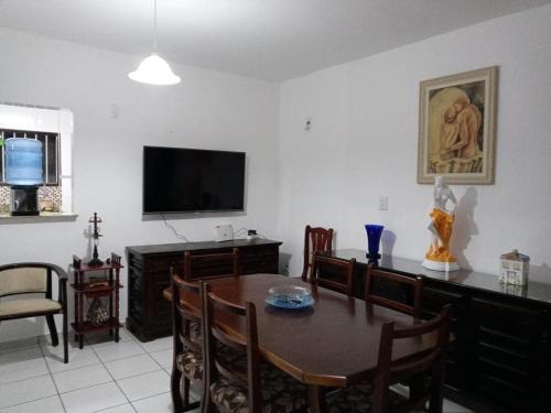a dining room with a table and a television at Casa do Tio Eri - Geribá - 100 metros da Praia in Búzios