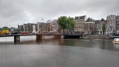 a bridge over a river in a city with buildings at Rembrandt Square Boat in Amsterdam