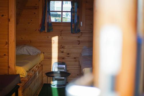 mały pokój z 2 łóżkami w drewnianym domku w obiekcie Camping Le pommier rustique w mieście Yvoir