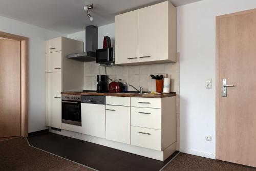 a kitchen with white cabinets and a sink at Pension Lemke in Polchow
