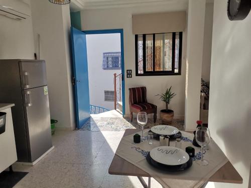a kitchen with a table with wine glasses on it at BEL APPART A SiDi BOUSAID in Sidi Bou Saïd
