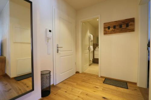 a hallway with a mirror and a door at Ferienwohnungen im Gasthof Stern inklusive KönigsCard in Unterammergau
