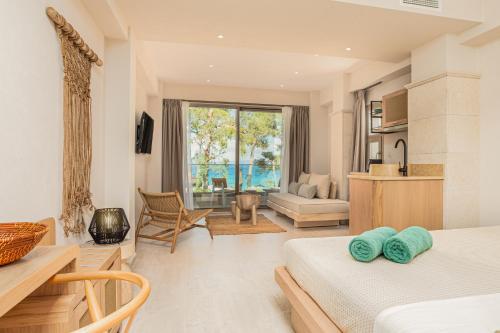 a bedroom with two beds and a living room at MAKO Sea & Suites in Pefkohori