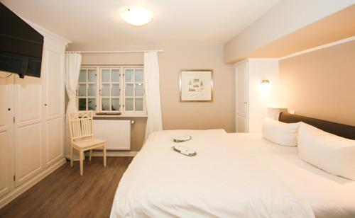 ヴェニングシュテットにあるAm Heidepark, App 3 Eのベッドルーム(白いベッド1台、椅子付)