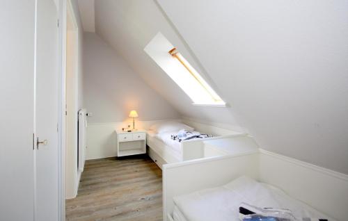 ヴェニングシュテットにあるC-Haus Cordula, App 41のベッドと天窓付きの小さな屋根裏部屋です。