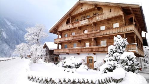 a large wooden building covered in snow at Landhaus Eberler in Mayrhofen