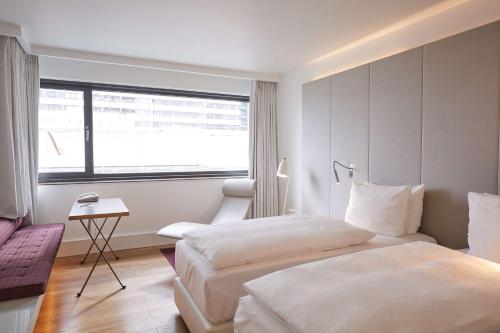 a hotel room with two beds and a window at Scandic Frankfurt Museumsufer in Frankfurt/Main