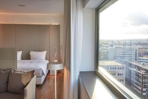 a hotel room with a bed and a large window at Scandic Frankfurt Museumsufer in Frankfurt/Main