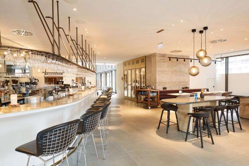 a restaurant with a bar with chairs and tables at Scandic Frankfurt Museumsufer in Frankfurt/Main