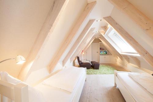 a attic room with two beds and a chair at Sommerhaus Malmö, App 2 in Wenningstedt