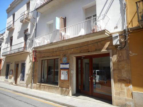 - un bâtiment avec une porte et un balcon dans une rue dans l'établissement Hotel del Mar, à Sant Feliu de Guíxols