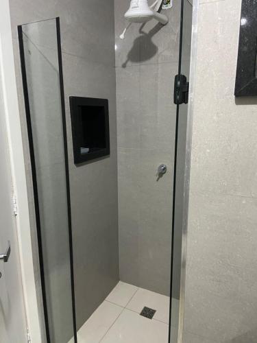 W łazience znajduje się prysznic ze szklanymi drzwiami. w obiekcie Apartamento de frente para o mar w mieście Guarapari