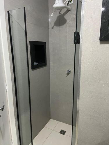 una doccia con una porta in vetro in un bagno di Apartamento de frente para o mar a Guarapari