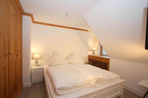 a bedroom with a white bed and a window at Hideaway in Kampen