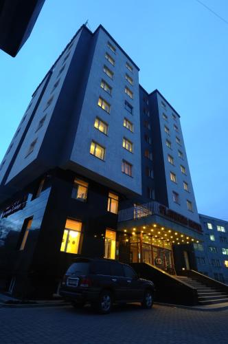 a building with a truck parked in front of it at Platinum Hotel Ulaanbaatar in Ulaanbaatar