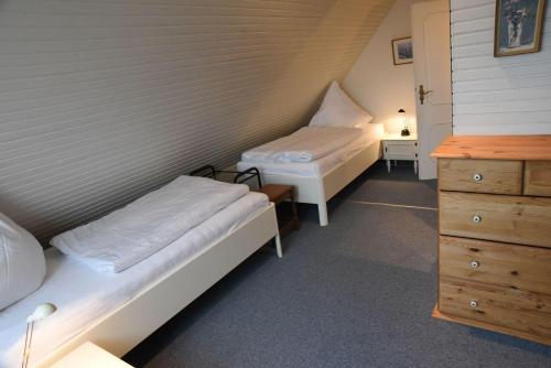 una piccola camera con due letti e un comò di Haus Nordseegruss, App 4 a Wenningstedt