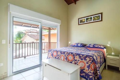 a bedroom with a bed and a balcony at UBATUBA PRAIA DO SAPE - bela casa em condominio - 01 Quadra da Praia, Wifi, Piscina, Churrasqueira e Forno de Pizza in Ubatuba