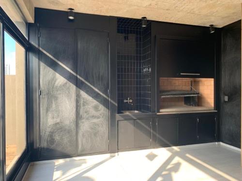 Una puerta negra en una habitación con ventana en Nuevo Loft en Palermo Hollywood en Buenos Aires