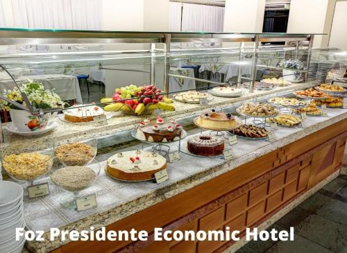 a buffet line with cakes and other desserts on display at Foz Presidente Economic Hotel in Foz do Iguaçu