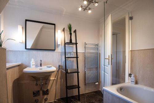 La salle de bains est pourvue d'un lavabo, d'une baignoire et d'un miroir. dans l'établissement Inselfreude Whg 10, à Westerland
