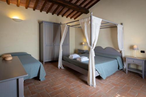 sypialnia z 2 łóżkami i łóżkiem z baldachimem w obiekcie Agriturismo Villetta Di Monterufoli w mieście Monteverdi Marittimo