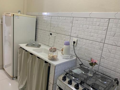 a small kitchen with a sink and a stove at Kitnet - Apart Hotel 3 in Sete Lagoas