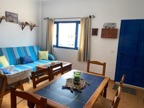 sala de estar con sofá azul y mesa en CASA LOS JUANES, en Caleta de Sebo