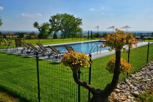 a fence with flowers on it next to a swimming pool at Agriturismo La Guarda in Picedo