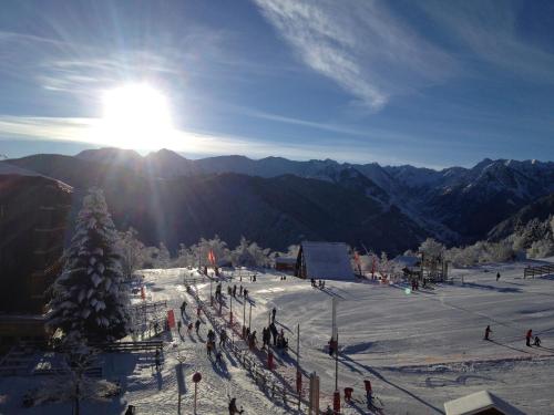 um grupo de pessoas numa pista de esqui na neve em Un Isard au Pied des Pistes em Ax-les-Thermes