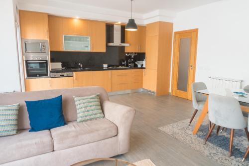 a living room with a couch and a dining room at Perola Mar in Nazaré