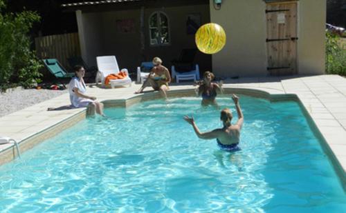 a group of people playing in a swimming pool at Le Grand Chemin de La Vie in Montcaret
