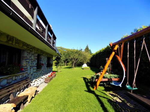 a garden with a swing next to a building at Pokoje u Teresy in Czarna Góra