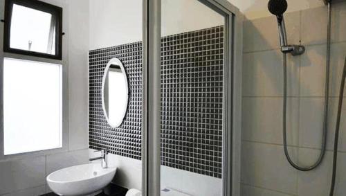 La salle de bains est pourvue d'une douche, d'un lavabo et d'un miroir. dans l'établissement Goodnight Cha Am Minitel, à Cha Am