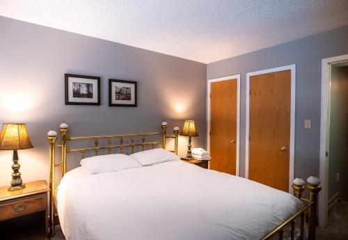 a bedroom with a bed and two lamps and two tables at Blue Mountain Slopeside Chalet in Chateau Ridge in Blue Mountains